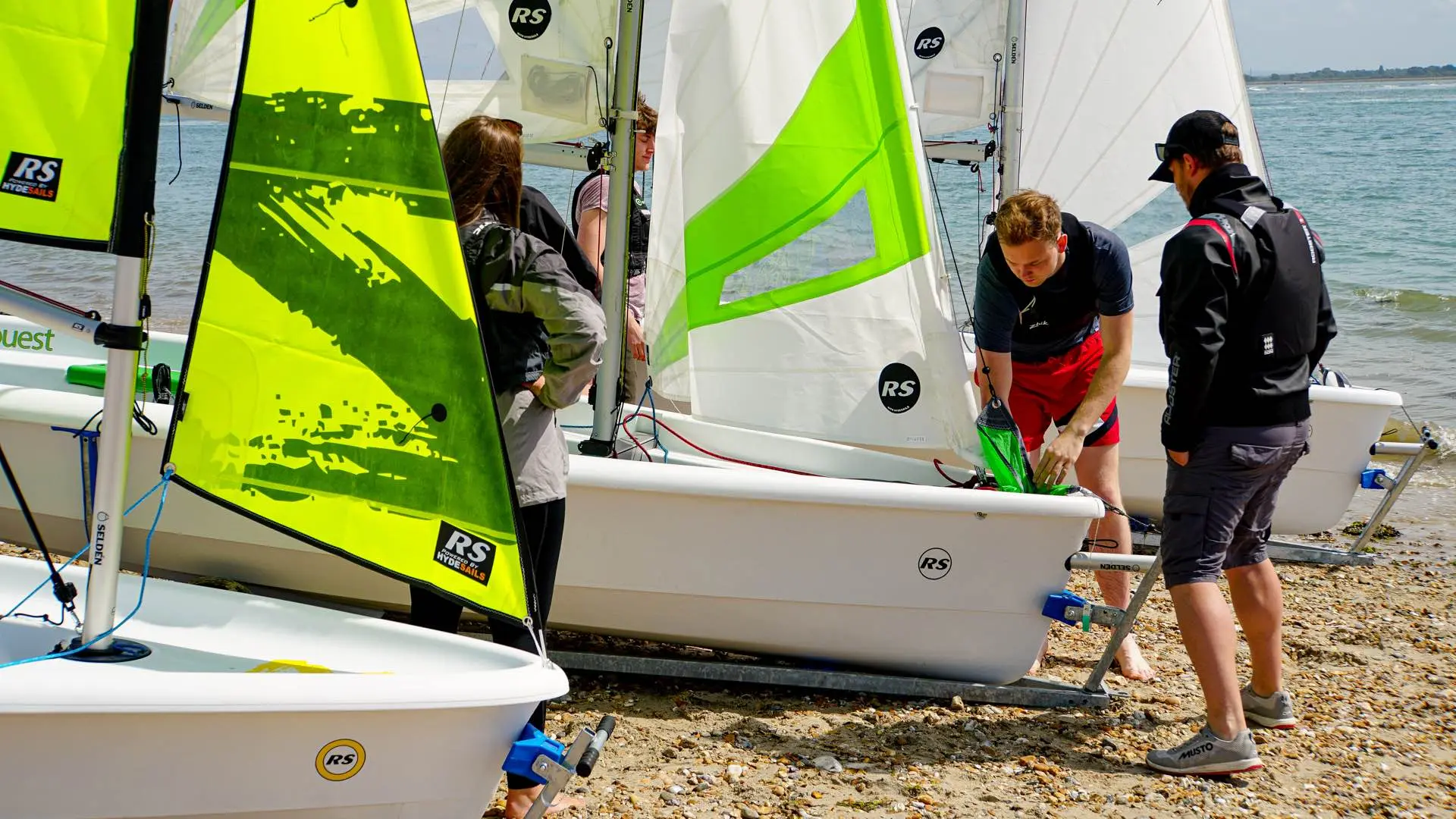 RS-Segeljollen Zest, Quest und Toura am Strand, Segler machen die Boote segelklar